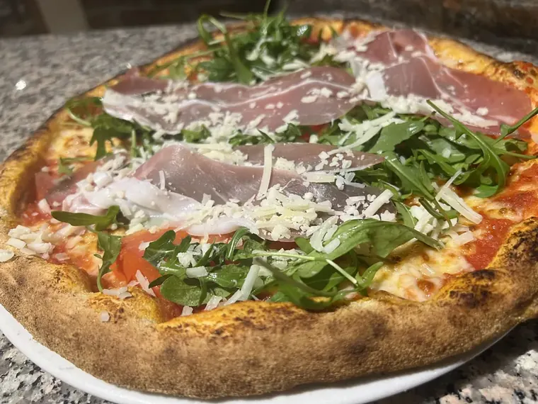 Pizza Mediterrana mit Parmaschinken, Rucola und Parmesan